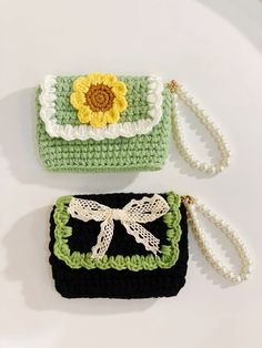 two crocheted purses sitting next to each other on a white table top