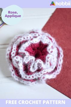 a close up of a crocheted brooch on a piece of paper with the words rose applique