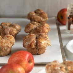 some apples and muffins are sitting on the table