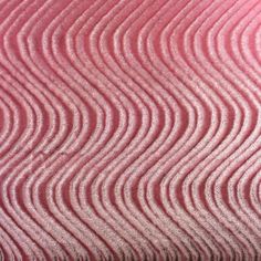 a close up view of pink and white waves on the surface of a table cloth