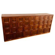 a large wooden cabinet with many drawers on the top and bottom, in front of a white background