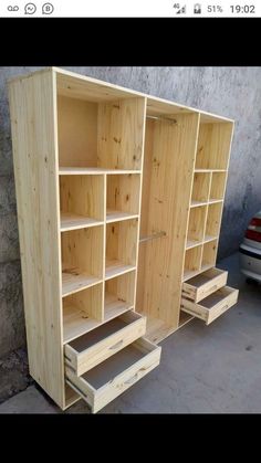 an unfinished closet with drawers and shelves in front of a wall next to a car