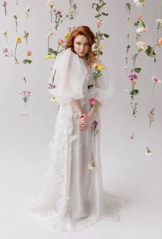 a woman in a white dress with flowers around her