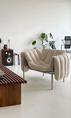 a living room filled with furniture and a coffee table in front of a wall mounted speaker