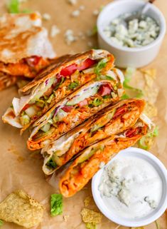 several tortilla sandwiches on a table with dips