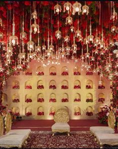 a decorated stage with red flowers and chandeliers