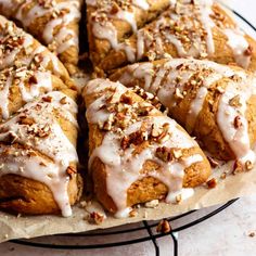 a cake with white icing and nuts on top is sitting on a wire rack