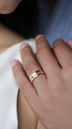 a close up of a person's hand with a gold ring on their finger