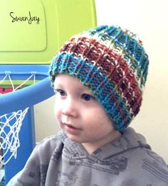 a young boy wearing a knitted hat next to a basketball hoop