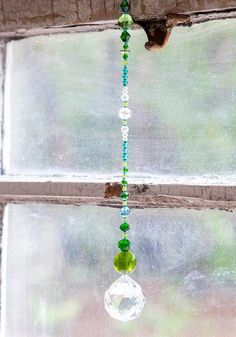 a glass beaded wind chime hanging from a window