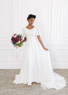 a woman in a wedding dress holding a bouquet