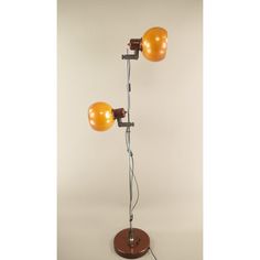 an orange lamp on a wooden base with two bulbs attached to it and one bulb turned off