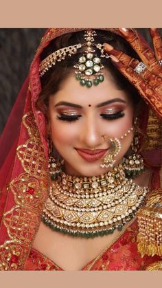 a woman wearing a red and gold bridal outfit