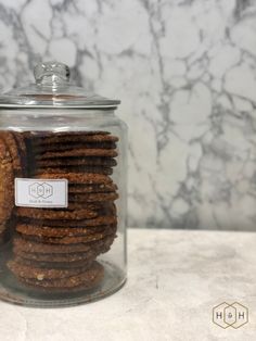 a glass jar filled with cookies on top of a counter