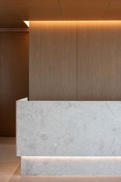 a white marble counter sitting in front of a wall with wooden paneling on it