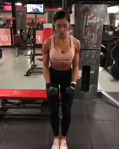 a woman standing in the middle of a gym