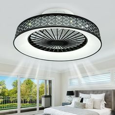 a bed room with a neatly made bed and a fan on the ceiling above it