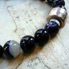 "This is a stunning statement necklace. Purple tone agate stones create a very unique piece. A silver plated bead is placed on the side to give an asymmetric modern look. The necklace combines smaller beads (approx. 1,4 cm) with bigger beads (approx. 1.8 cm) Agate's most noticeable properties overall are balancing yin/yang energy, courage, protection, healing, and calming. Historically it was placed in water for cooking or drinking to dispel sickness. The Metaphysical and Healing Properties Lore Modern Polished Beads Necklace For Gift, Silver Agate Round Beads Necklace, Silver Agate Necklace With Round Beads, Silver Beads, Gems, And Cabochons For Gifts, Elegant Agate Beads For Gifts, Agate Spacer Beads Jewelry Gift, Elegant Gemstone Beads For Gifts, Silver Agate Necklace With Polished Beads, Silver Agate Jewelry With Large Beads