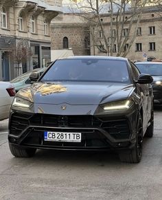 a black sports car parked on the side of the road in front of other cars