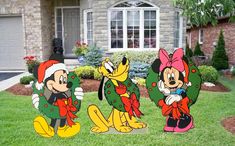 three mickey and minnie christmas yard decorations in front of a house