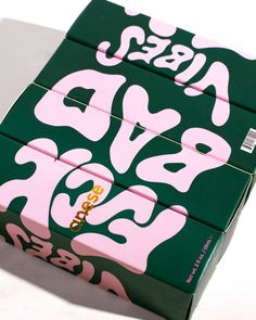 the box is green and pink with white letters on it's sides, as well as words that spell out