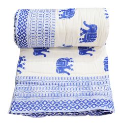 two blue and white bedspreads with an elephant design on the bottom one is made from cotton