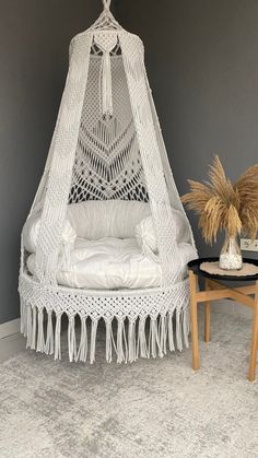 a white hammock chair sitting next to a table