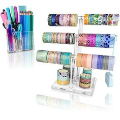 several rolls of washi tapes are stacked on a rack with pens and pencils