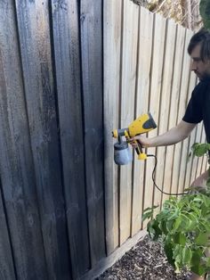 a man is using a power drill to fix a fence