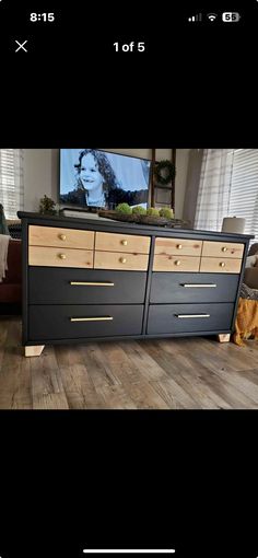 an image of a tv on a dresser in a living room with wood floors and windows