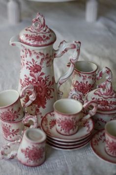 an assortment of red and white china on a table