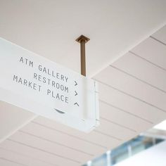 a white sign hanging from the ceiling that says atm gallery rest room market place on it