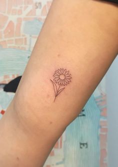 a small flower tattoo on the arm