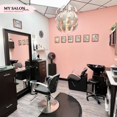 a salon with pink walls and black chairs