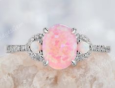 an opal and diamond ring on top of a rock