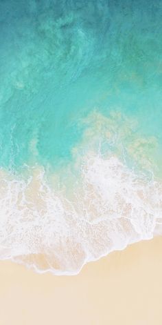 an aerial view of the ocean and sandy beach