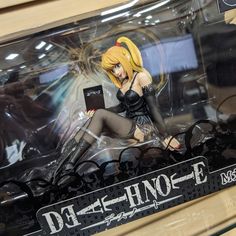 a doll sitting on top of a table in a display case with an electronic device