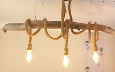 several light bulbs are hanging from a wooden beam with rope wrapped around them and hung on the ceiling