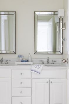 two bathroom sinks with mirrors above them and a rug on the floor in front of them