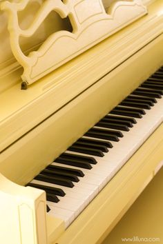 a white piano sitting in front of a window