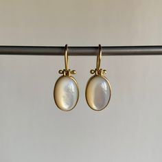 Mother of pearl shimmers sweetly at the end of buttery gold ear wires in this dreamy pair. 18k yellow gold Mother of pearl, 8.08ctw, 8mm x 11mm (5/16" x 1/2") Earrings hang 7/8" from the ear Each earring weighs 2g Elegant Yellow Gold Dangle Pearl Earrings With High Luster, Elegant Drop Earrings With Cabochon, Elegant Yellow Gold High Luster Dangle Pearl Earrings, Yellow Gold Pearl Drop Earrings In Mother Of Pearl, Yellow Gold Pearl Drop Earrings With Mother Of Pearl, Yellow Gold Mother Of Pearl Earrings, Classic Gold Mother Of Pearl Earrings, Classic Mother Of Pearl Gold Earrings, Yellow Gold Brass Pearl Earrings