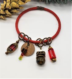 This bangle bracelet is wrapped with red suede cord and wire wrapped with one station.  The dangles are made up of antique bronze color metal, red & amber color glass, agate and howlite beads. The coin is a 1978 one penny from the UK.  This bracelet has an approx. 2 1/2" inside diameter.  This is average size and will fit most. #033 All coin pieces are sold as re-purposed coins and as such have no monetary value as currency. Bohemian Red Jewelry With Charms, Nickel Free Red Bohemian Bracelets, Nickel-free Red Bohemian Bracelets, Red Bohemian Nickel-free Bracelets, Red Nickel-free Bohemian Bracelets, Adjustable Red Wire Wrapped Jewelry, Adjustable Wire Wrapped Red Jewelry, Adjustable Red Wire-wrapped Jewelry, Red Adjustable Wire Wrapped Bracelets