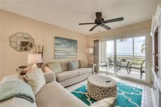 a living room filled with furniture and a ceiling fan