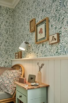 a bedroom with a bed, desk and pictures on the wall above it that is decorated in blue and green