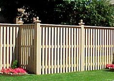 a wooden fence in the middle of some grass