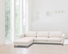 a living room with white furniture and large windows