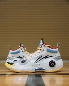 a pair of white and blue sneakers on top of a basketball court