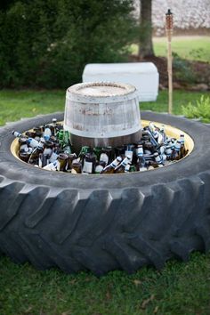 an old tire turned into a planter filled with beer bottles