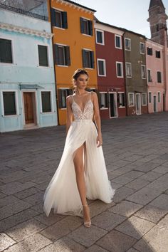 a woman in a white dress is standing on the street with her legs spread out