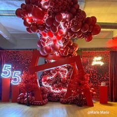 a bunch of balloons that are in the shape of a heart on a table with red decorations